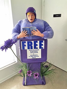 Mannequin reads Sandra Brown book; sign reads FREE books are provided by Gulf County Library System & distributed by St. James' Episcopal Church