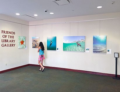 Photo of a patron viewing art in the Friends of the Library Gallery