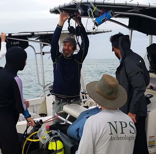 Man talking to other men on a boat